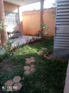 einen Garten mit Felsen im Gras neben einem Haus in der Unterkunft Résidence Wendyna in Ouagadougou