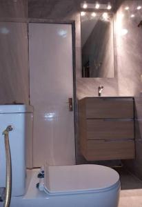 ein Badezimmer mit einem weißen WC und einem Waschbecken in der Unterkunft Résidence Wendyna in Ouagadougou