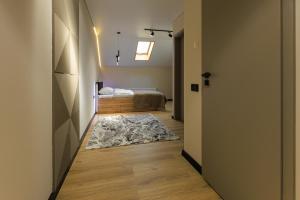 a hallway with a room with a bed and a rug at Discovery Garden apartments in Khmelʼnytsʼkyy
