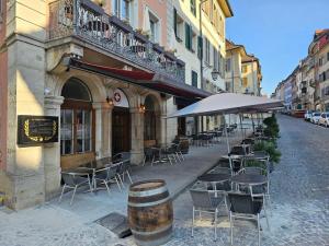 um café com mesas e cadeiras e um guarda-sol em La Vie est Belle em Porrentruy