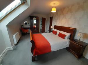 a bedroom with a bed with a red blanket at Cliffs View Self Catering @ Limestone Lodge in Doolin