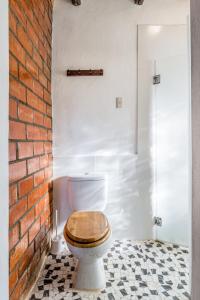 a bathroom with a toilet with a brick wall at Fundo Chincheros Lodge in Juliaca