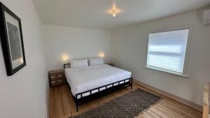 a white bedroom with a bed and a window at The Parador in Santa Fe