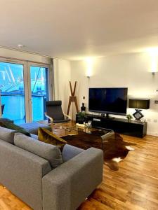 Luxury apartment in Canary Wharf في لندن: غرفة معيشة مع أريكة وتلفزيون بشاشة مسطحة