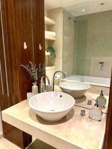Luxury apartment in Canary Wharf في لندن: حمام مع حوض وحوض استحمام