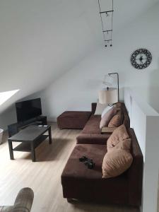 a living room with a couch and a table at Gîte "Aux Pieds des Ar'den" la chambre 1 est fermée et la chambre 2 est dans le hall de nuit séparée par un rideau in Houyet