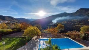 a swimming pool with a view of the mountains at Casa Rural Olivillas Garden-Sierra Nevada in Güéjar-Sierra