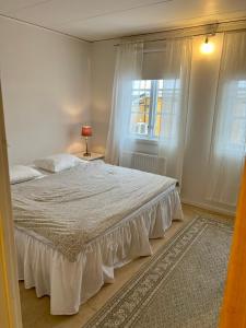 a bedroom with a white bed with a window at Central lägenhet in Norrtälje