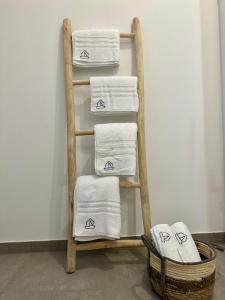 a towel rack with four towels and a basket at Dümmerland Apartments in Lemförde