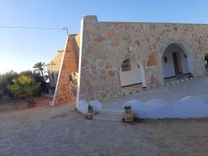 um edifício com uma parede de pedra e uma escada em Maison á la campagne em El Guecheïne