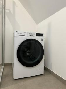 a white washing machine in a corner of a room at Dümmerland Apartments in Lemförde