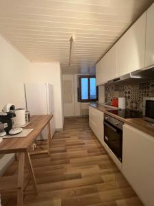 uma cozinha com uma mesa de madeira e um piso de madeira em La Vie est Belle em Porrentruy