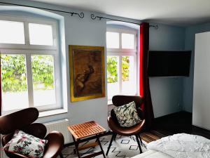 sala de estar con 2 sillas, 1 cama y 2 ventanas en Haus Goodewind en Ahlbeck