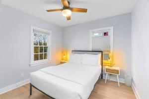 a white bedroom with a bed and a ceiling fan at Skyline Blue House in Greenwood in Seattle