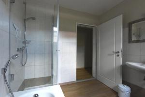 uma casa de banho com um chuveiro e um lavatório. em Sylvia Helene Lafrenz em Winkl bei Grabenstätt