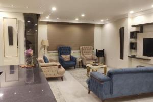 a living room with blue couches and chairs at Comfortable softness in Cairo