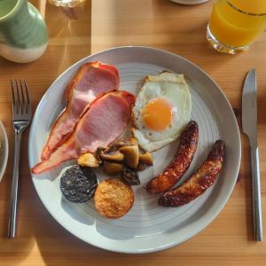 a plate of breakfast food with eggs bacon and other foods at An Creagán Bed and Breakfast in Inisheer