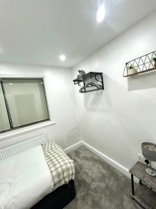 a bedroom with a bed and a window and a table at Cosy 3 bedroom Near Heathrow - 6 beds, sleeps 7, FREE PARKING in Staines upon Thames