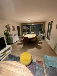 een woonkamer met een tafel en een gele kruk bij Chalet Le Cèdre Bleu 10 p - 10 min de Gérardmer in Le Tholy