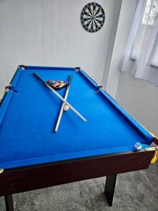 a pool table with two cuesticks on top of it at Cosy 3 bedroom Near Heathrow - 6 beds, sleeps 7, FREE PARKING in Staines upon Thames