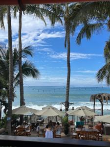 un restaurante con palmeras y vistas a la playa en Los Corales, en Máncora