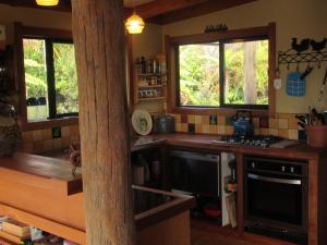 a kitchen with a stove and a counter with windows at Beaconstone Eco Stay - off grid retreat in Charleston