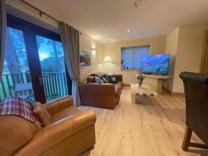 ein Wohnzimmer mit 2 Sofas und einem TV in der Unterkunft Lake District romantic get away in 1 acre gardens off M6 in Penrith