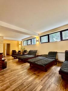 a large room with couches and tables and windows at Pamporovo Rhodopi Pearl Apartments - Private Apartments in Pamporovo