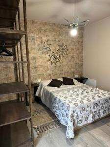 1 dormitorio con 1 cama grande y pared de madera en Casa Rural La Antigua Fonda (@casarural_laantiguafonda), en Requena