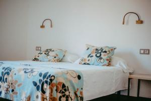 a bedroom with a bed with a blanket and pillows at Hostal Restaurant Mussons Vins in Poboleda