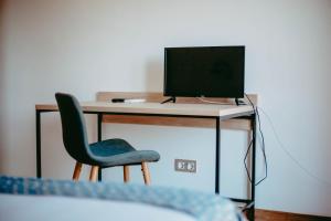 a desk with a computer monitor and a chair at Hostal Restaurant Mussons Vins in Poboleda