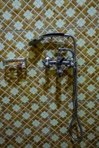 un soffione doccia sul muro di un bagno di Crown Inn Bulindo a Wakiso