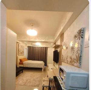 a small room with a bed and a tv at Condotel-Shore 2 Residences MOA in Manila