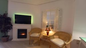 a living room with two chairs and a fireplace at El rinconet in Partida de La Cañada