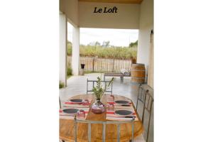 een tafel op een veranda met een bord waarop de lot staat bij Manade de la clapiere-Mas du Plan in Le Cailar