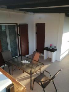 a living room with a glass table and chairs at Vitali sea house I in Vitálion +23 photos