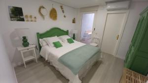 a bedroom with a bed with a green headboard at El rinconet in Partida de La Cañada