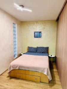 een slaapkamer met een bed met blauwe kussens bij Confort City Residence in Popeşti-Leordeni