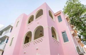 a pink building with a tree in front of it at 610@Miramar in San Juan