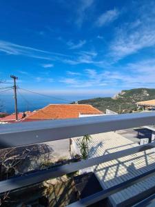 a balcony with a view of a house and the ocean at Ionian Balcony in Athanion