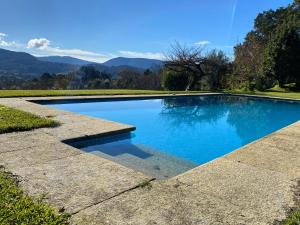 una piscina de agua azul y montañas de fondo en Pazo de Villares, en Gondomar