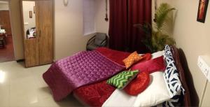 a bed with colorful blankets and pillows on it at Silver Spruce 2BHK Entire Floor Kotagiri in Kotagiri