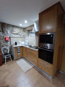 uma cozinha com armários de madeira e um forno com placa de fogão em Casa dos Avós em Avelal