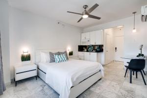 Dormitorio blanco con cama y mesa en Best location in SOBE - 2 min to beach & Ocean Dr, en Miami Beach