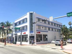 Biały budynek na rogu ulicy z ludźmi przechodzącymi przez ulicę w obiekcie Best location in SOBE - 2 min to beach & Ocean Dr w Miami Beach