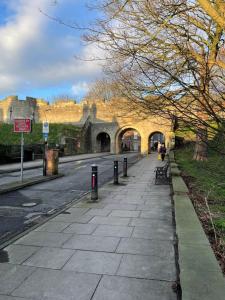 an empty sidewalk in front of a castle at Nunnery lane 3 bedroom house in York
