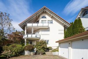 a white house with a balcony on top of it at Ferienwohnung Julija Riedheim in Hilzingen