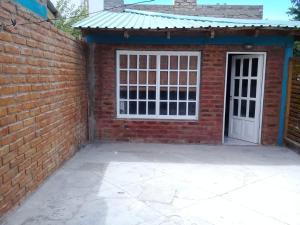 un garage en briques avec une porte blanche et un mur en briques dans l'établissement Dpto Al Paso, à Zapala