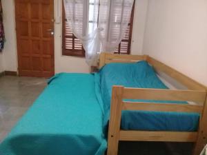 - une chambre avec un lit doté de draps bleus et une fenêtre dans l'établissement Dpto Al Paso, à Zapala