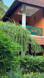 une maison avec une bande de plantes devant elle dans l'établissement Garggi Kumarakom Village Homestay, à Kumarakom